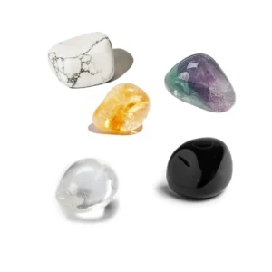 Top-down studio view of five polished natural tumbled crystals for the Sagittarius zodiac sign arranged cleanly on a solid white background.