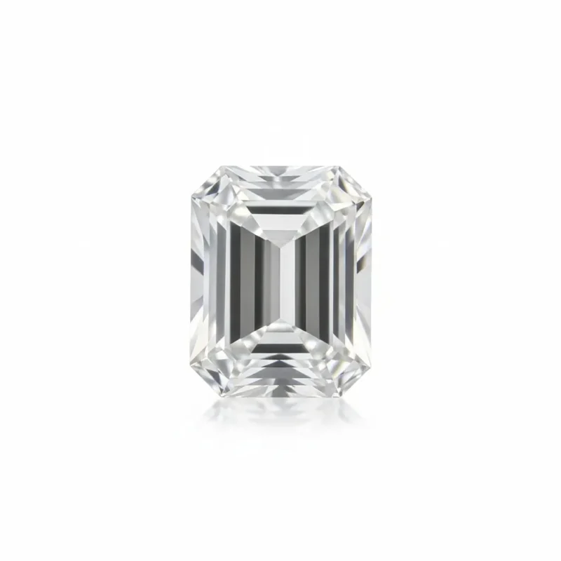 Top-down macro view of a loose Emerald cut moissanite diamond simulant isolated against a pure white background, showcasing its distinct rectangular step-cut facets and clean D-color clarity.