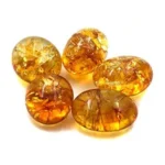 Studio cluster of five smooth, oval golden-amber Citrine tumbled stones isolated on a pure white background, showcasing radiant internal crystal spangles for Solar Plexus Chakra wealth and manifestation.
