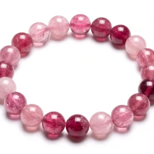 Top-down commercial product photograph of a premium natural gem-grade Pink Tourmaline 11mm beaded bracelet made of approximately eighteen (18) perfectly round beads on a pure #FFFFFF white background. The beautiful, 11mm beads showcase a rich, diverse range of natural pink hues—from delicate pale pastel pinks and soft rose to deeper magenta, raspberry, and dark fuchsia-pink—illustrating its genuine, un-dyed gemstone quality. Each bead features a semi-translucent to translucent quality with intricate internal structures, including natural feather-like patterns, faint inclusions, and micro-fractures that catch the light. Highly polished to a glassy, vitreous luster, the tightly packed bracelet is strung on a clear cord, creating subtle natural drop shadows on the surface, ideal for Heart Chakra healing.